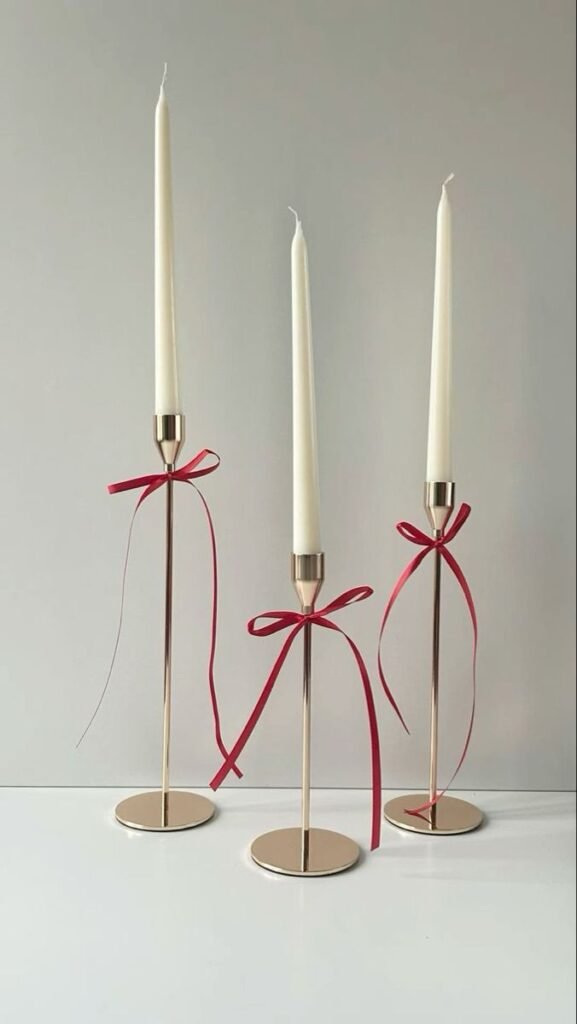 Velas blancas con lazos rojos en candelabros dorados
