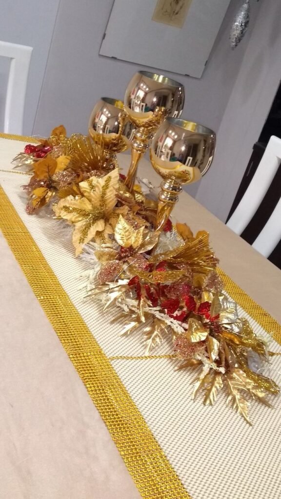 Centro de mesa dorado con velas sobre camino de mesa