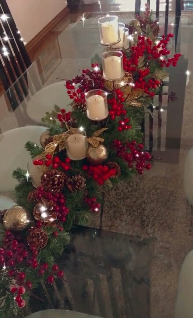 Centro con velas y ramas de bayas junto a la escalera