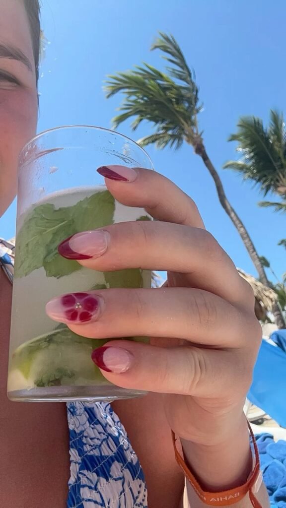 Uñas nude con una flor fucsia en el dedo anular