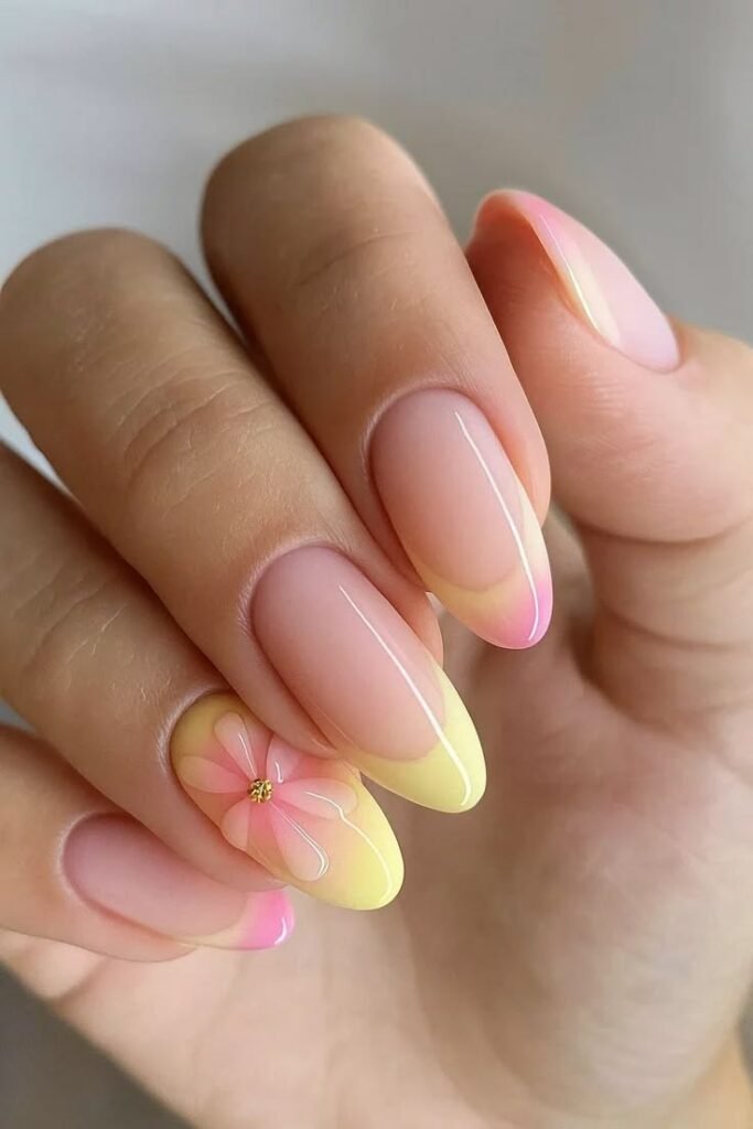 Uñas en degradado amarillo y rosa con una flor
