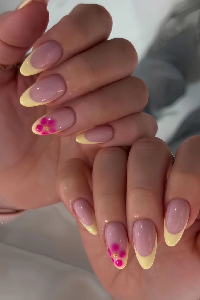 Uñas amarillo pastel con florecitas fucsia