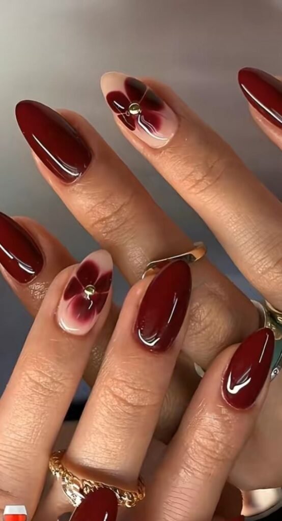 Uñas rojo burdeos con flores doradas pintadas