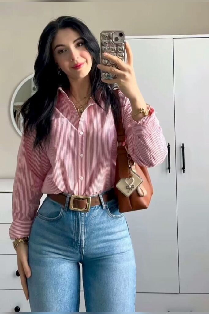 Camisa rosa con jeans claros y cinturón