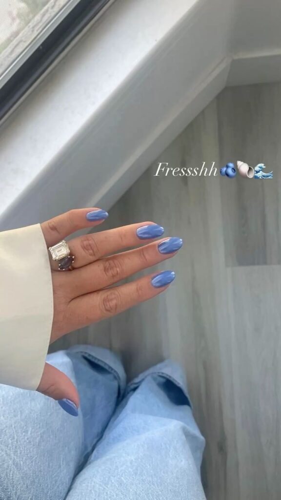Uñas azul claro con nubes blancas pintadas