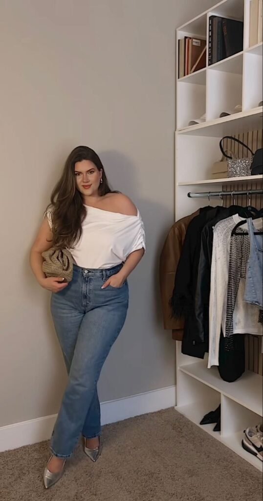 Camiseta blanca de un hombro con jeans acampanados